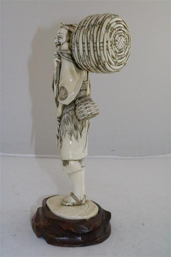 A large Japanese ivory figure of a fisherman, Meiji period, 25.5cm, wood stand